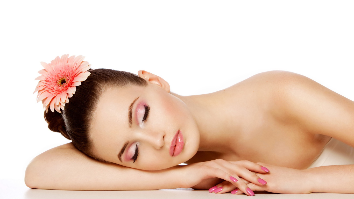 Нежная спящая девушка с красивым макияжем с цветком герберы в волосах