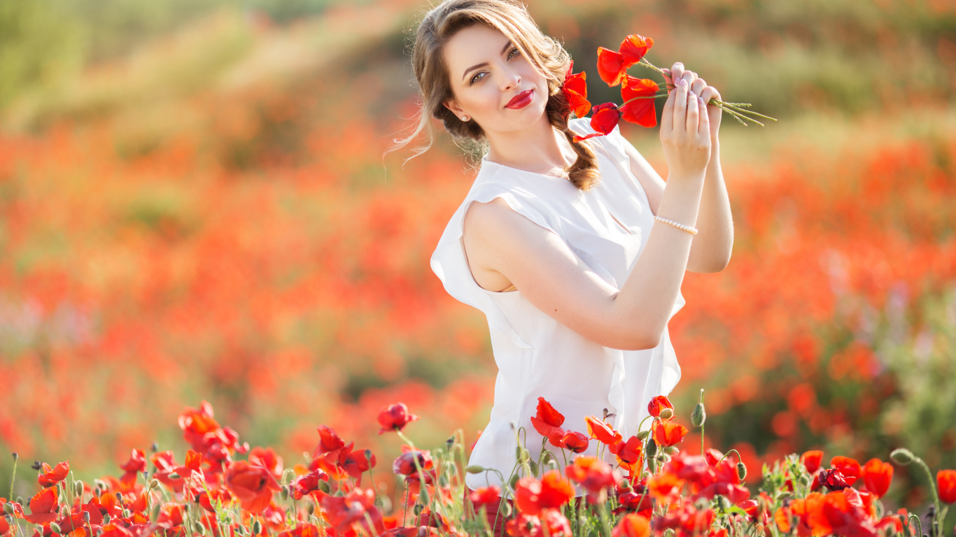 Красивая девушка в белом платье с букетом маков в руках