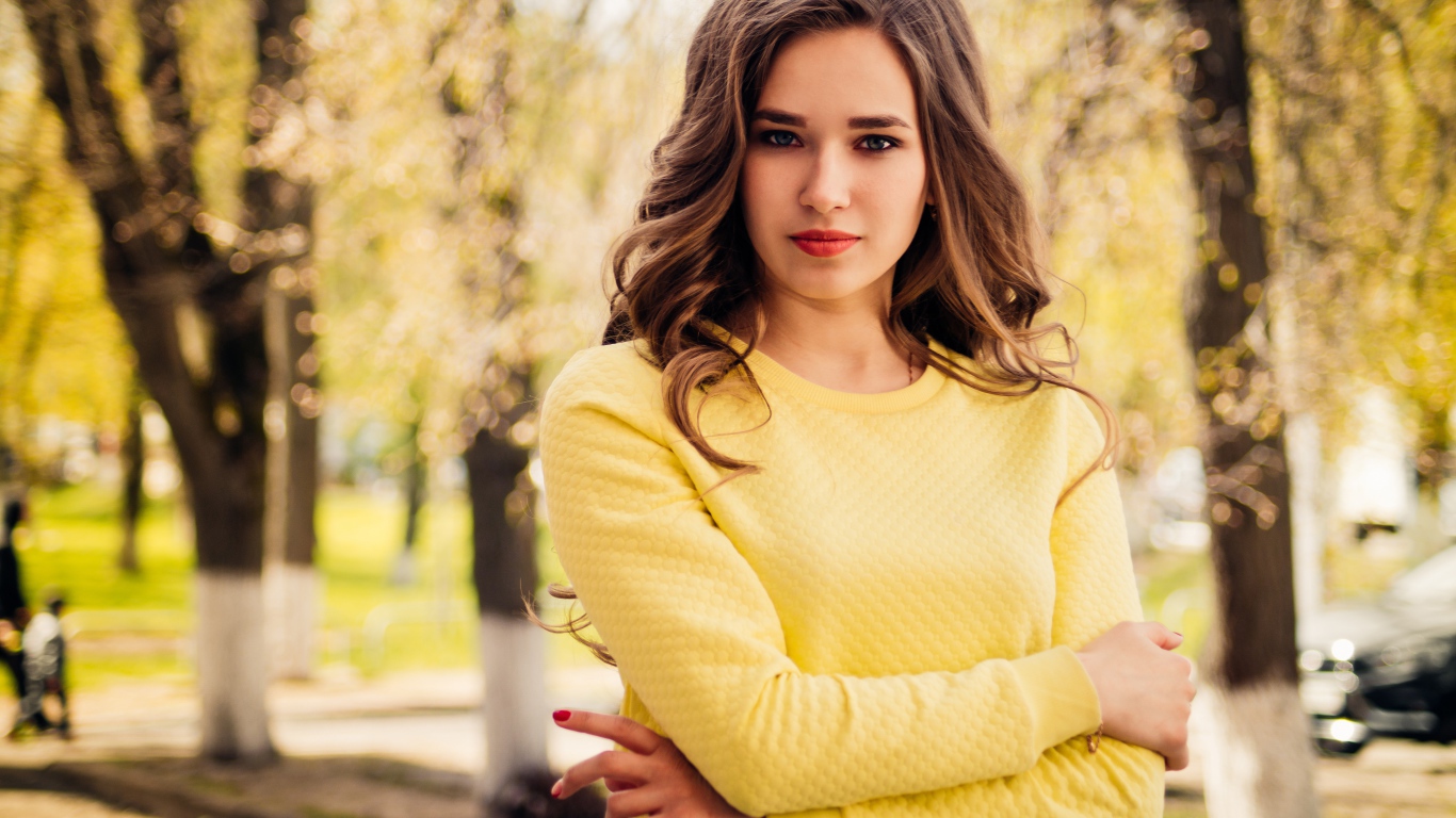 Красивая молодая голубоглазая девушка в желтом свитере