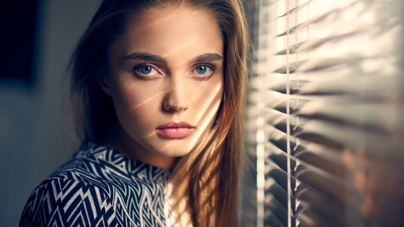 Девушка блондинка с голубыми глазами у окна 