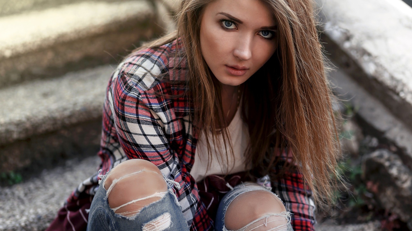 Голубоглазая девушка брюнетка в модных джинсах 