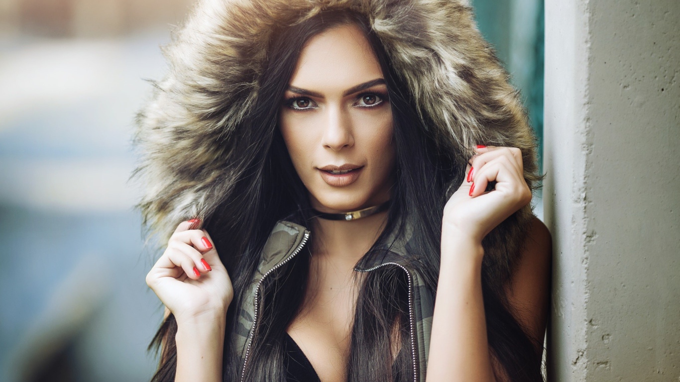 Брюнетка в капюшоне с красными ногтями на руках 