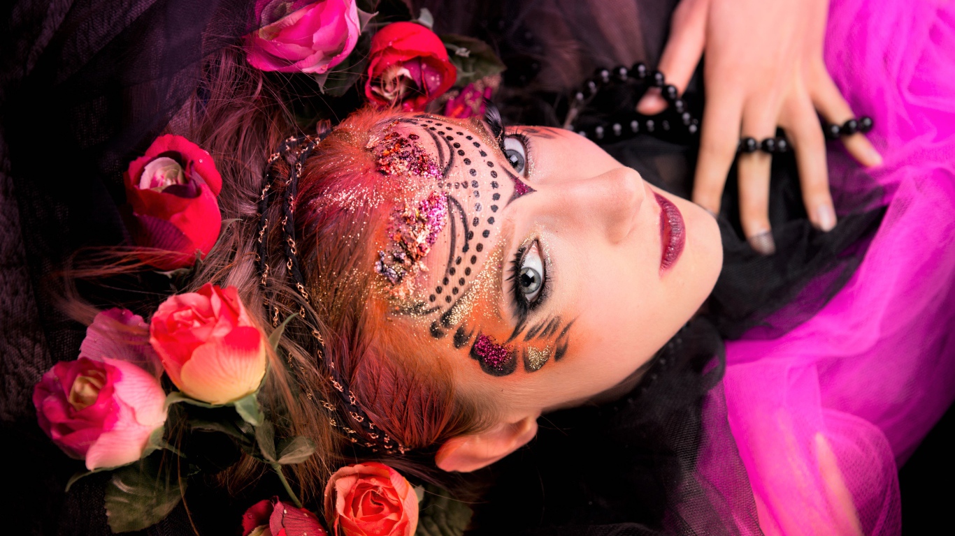 Девушка с блестящим ярким макияжем и розами в волосах