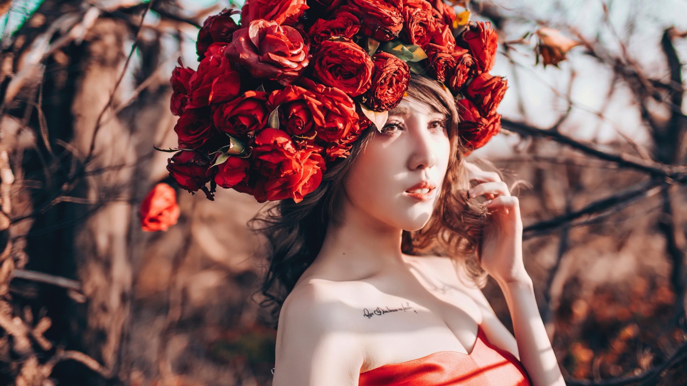 Молодая девушка азиатка с красными цветами на голове