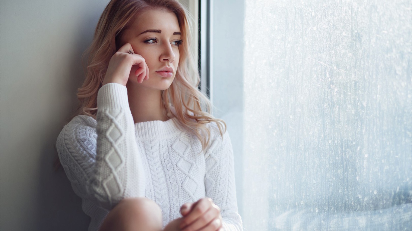 Молодая девушка блондинка у окна 