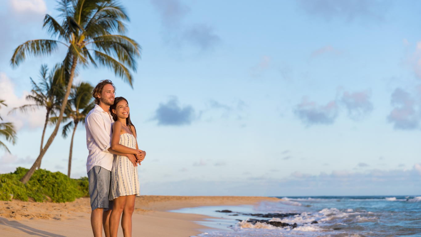 Влюбленная пара встречает закат на берегу океана