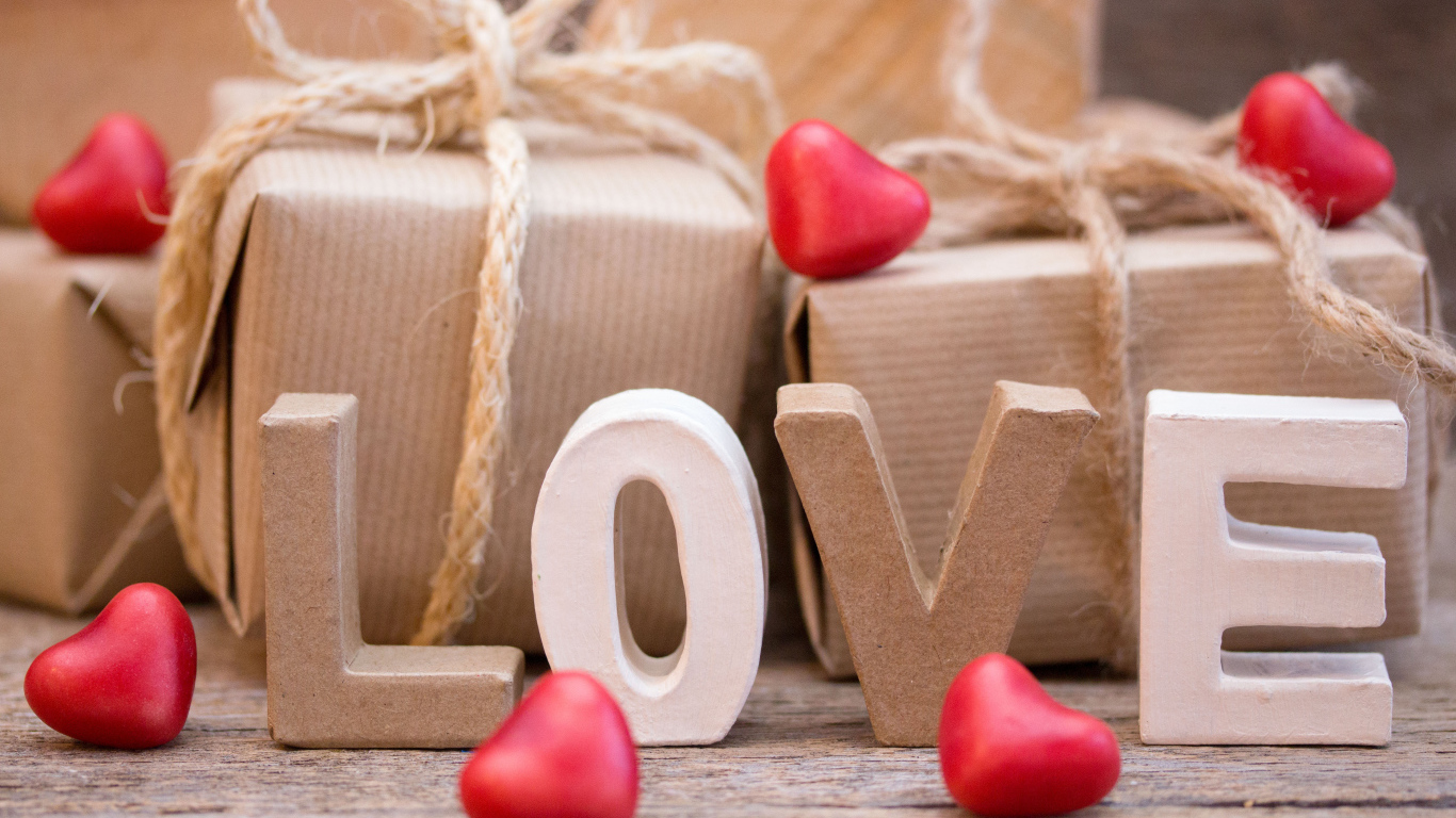 Романтические подарки и надпись Love с красными сердечками