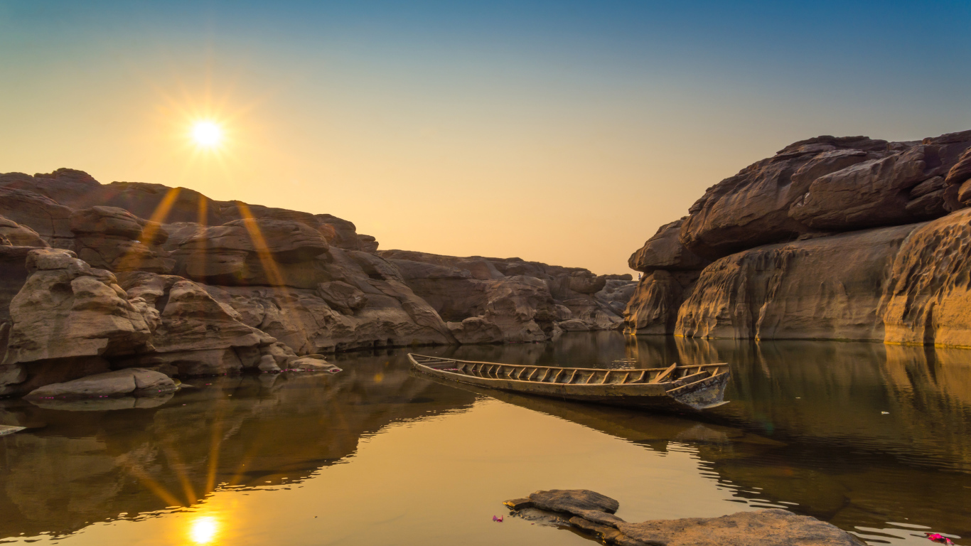 Лодна на озере между скал на рассвете