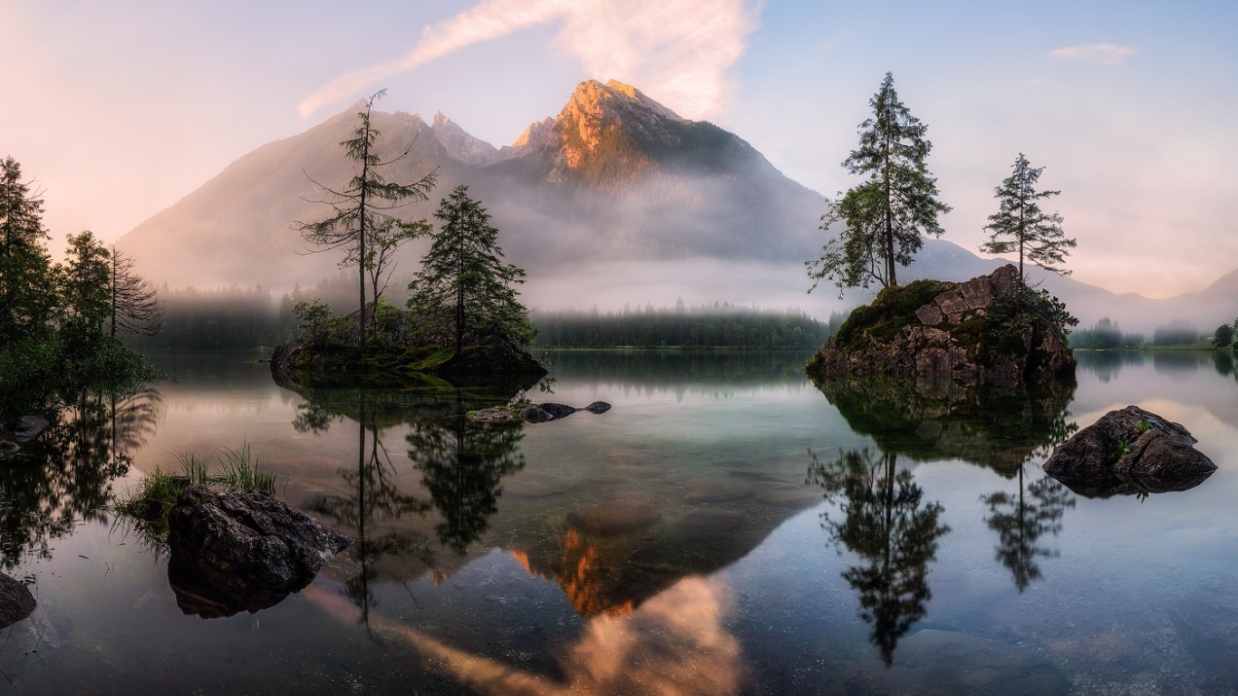 Горное озеро у покрытых туманом гор 