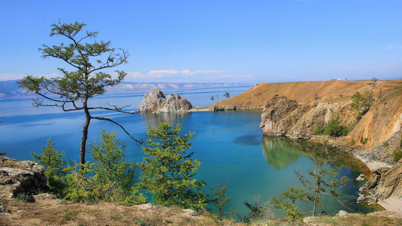 Каменные утесы у чистой воды живописного озера Байкал,  Россия