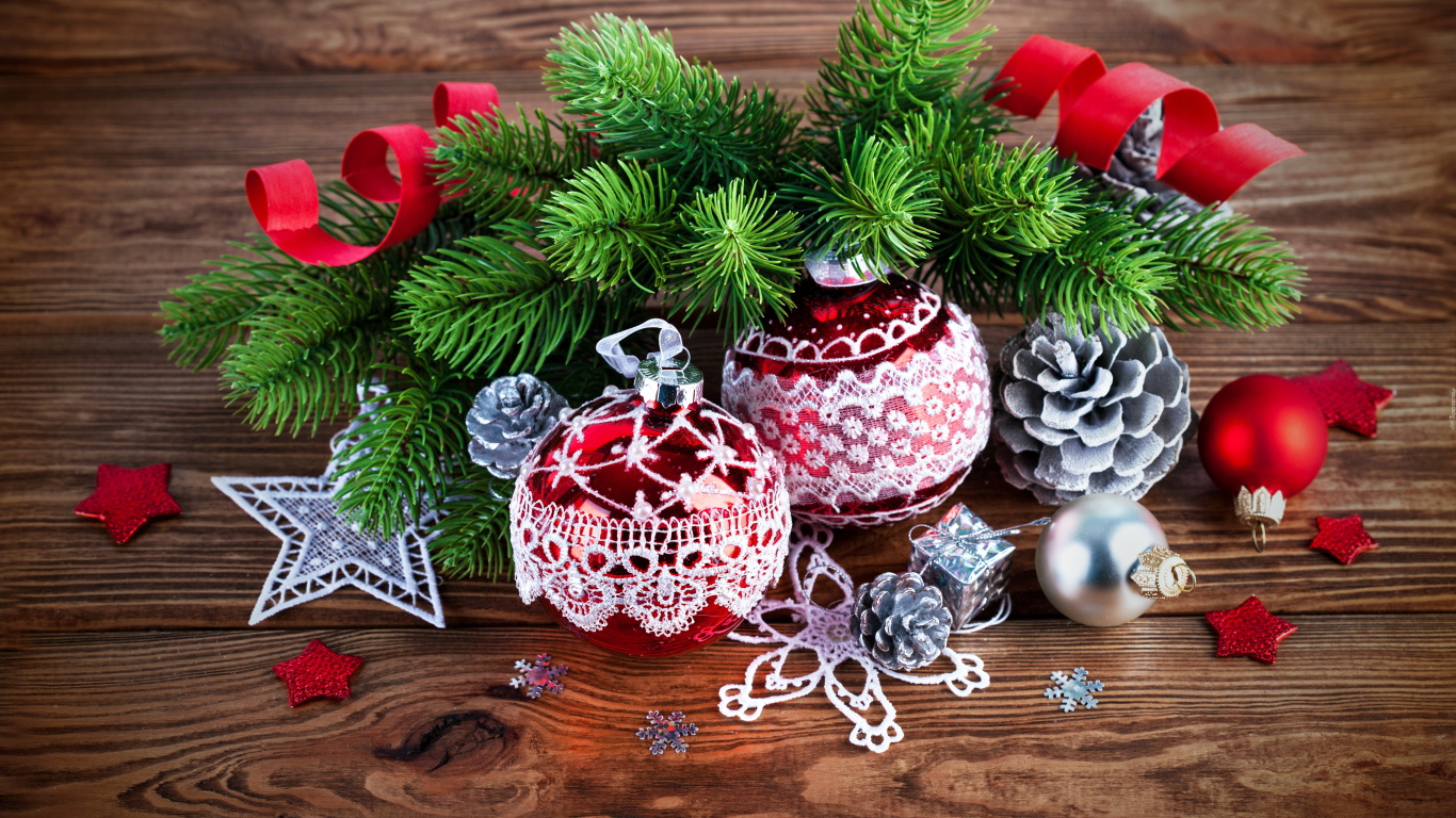 Красивые елочные игрушки с зеленой еловой веткой на деревянном столе 