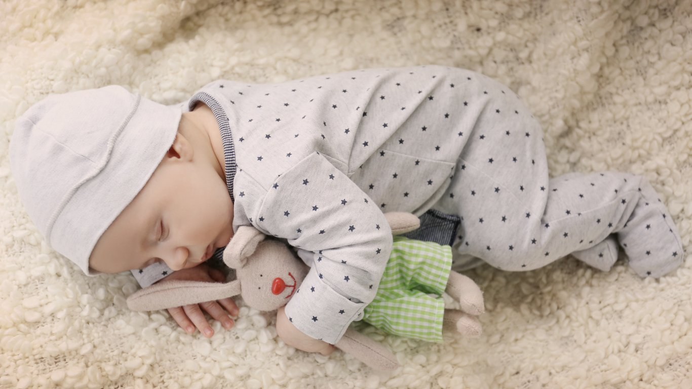 Грудной ребенок спит с любимой мягкой игрушкой