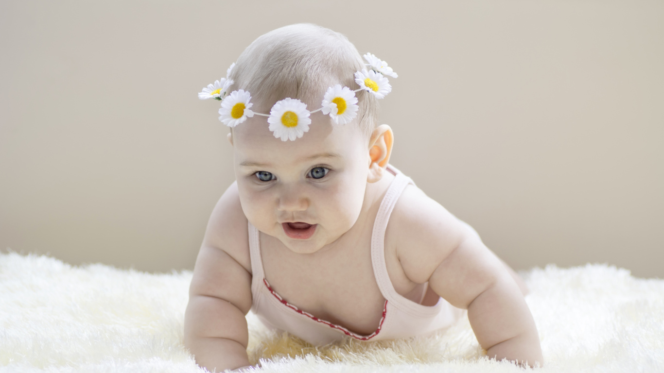 Грудной ребенок с венком из белых ромашек на голове