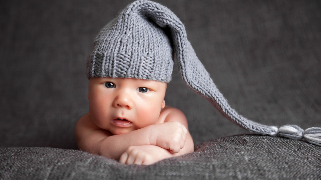 Милый младенец в большой серой вязаной шапке
