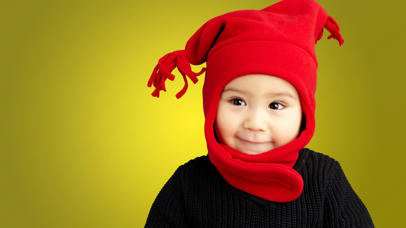 Маленький мальчик в красной шапке и в черном свитере