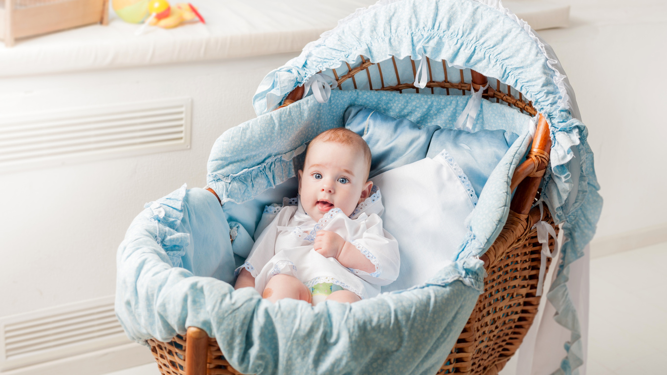 Маленький голубоглазый младенец в кроватке