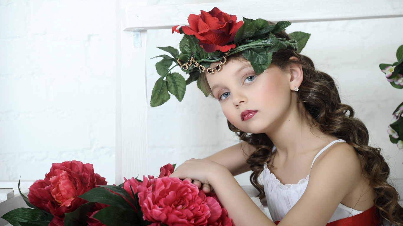 Красивая маленькая девочка с венком из роз на голове