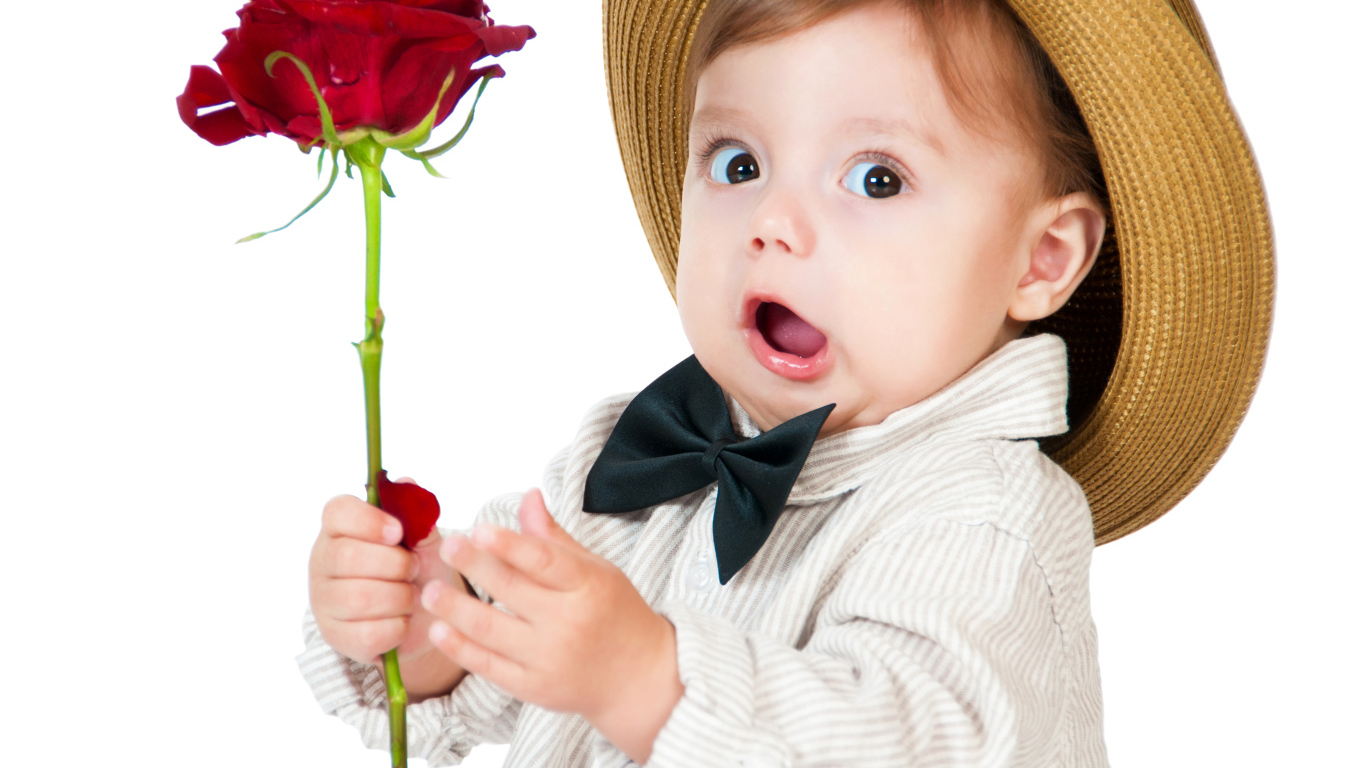 Забавный маленький мальчик в шляпе с красной розой в руке