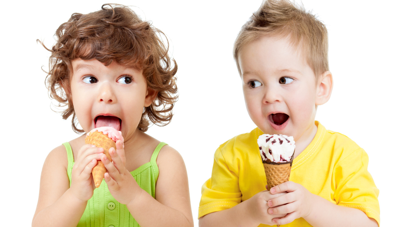 Маленькие мальчик и девочка едят вкусное мороженое