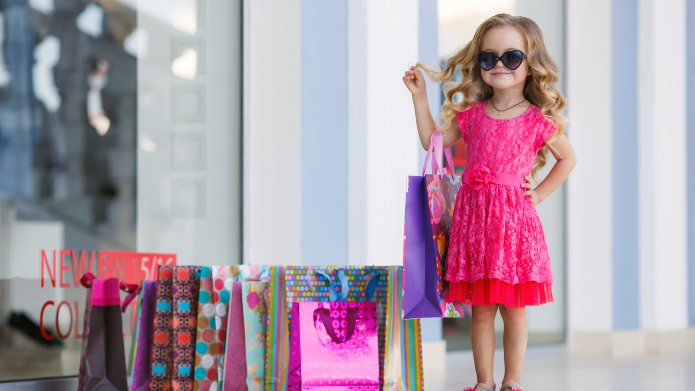 Маленькая модная девочка в красном платье с покупками