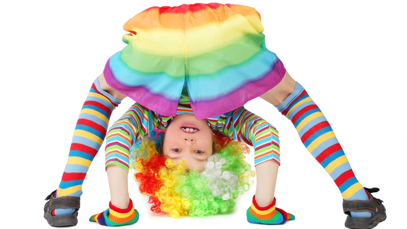 Маленькая смешная девочка в костюме клоуна на белом фоне