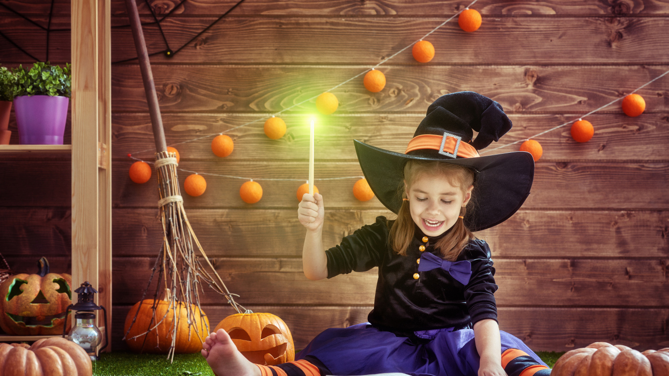Маленькая девочка в костюме ведьмы с волшебной книгой на Хэллоуин