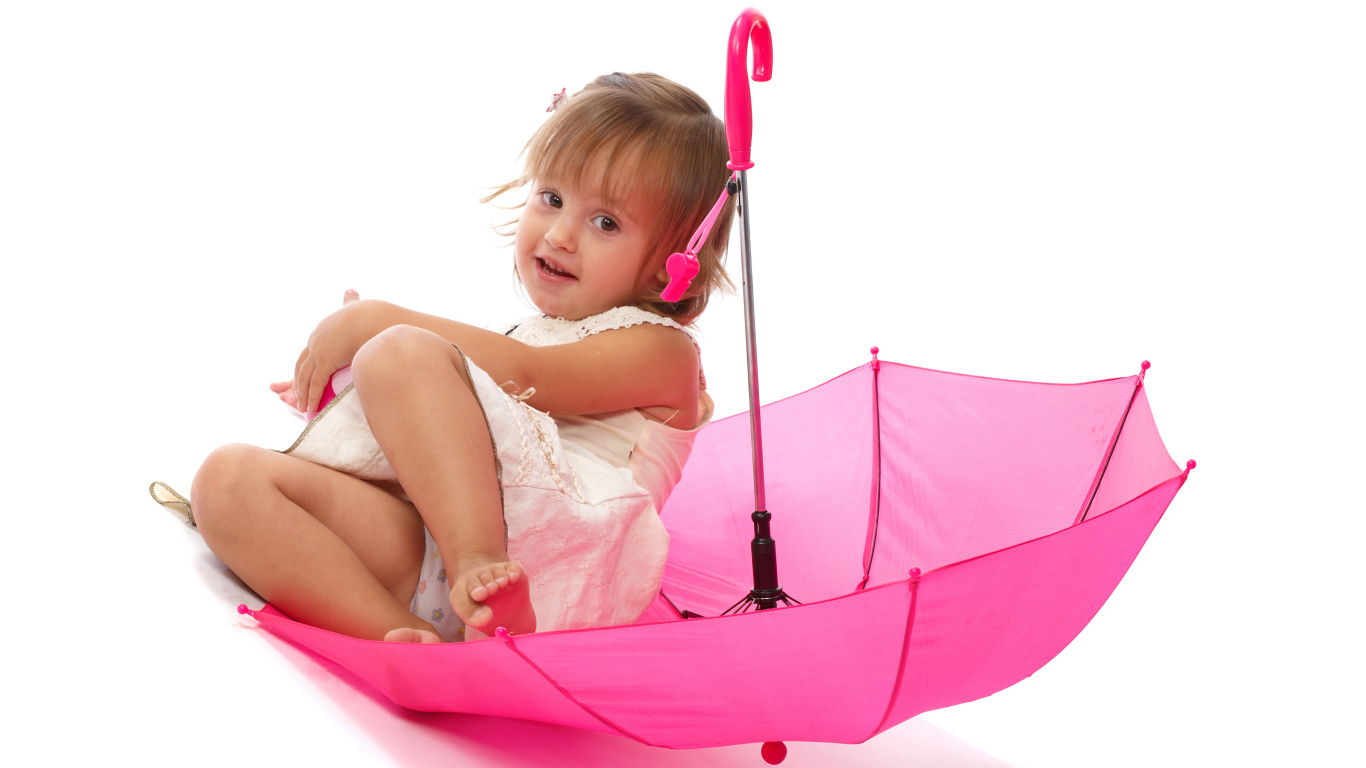 Маленькая девочка сидит в розовом зонте на белом фоне