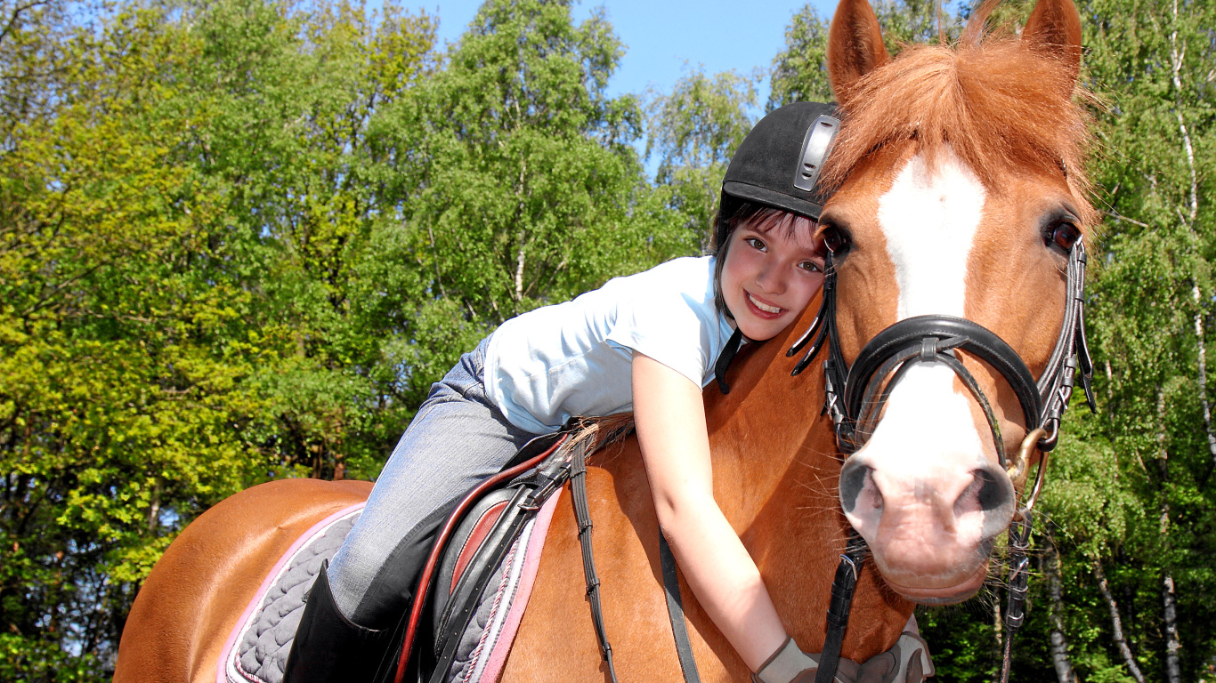 Маленькая девочка сидит на коричневой лошади