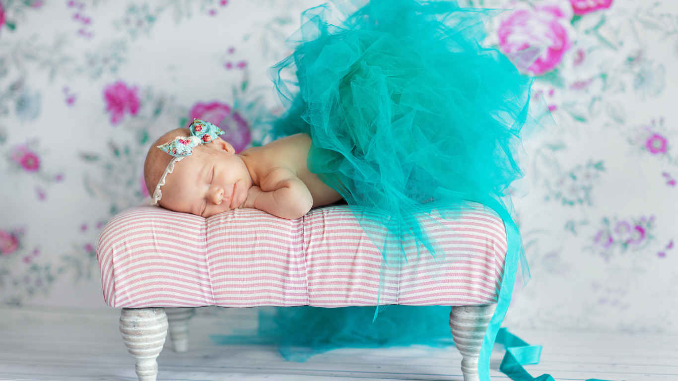 Маленькая девочка спит в красивом бирюзовом платье