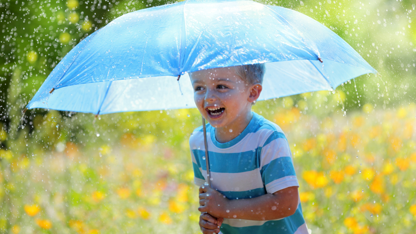 Маленький улыбающийся мальчик с голубым зонтом под дождем