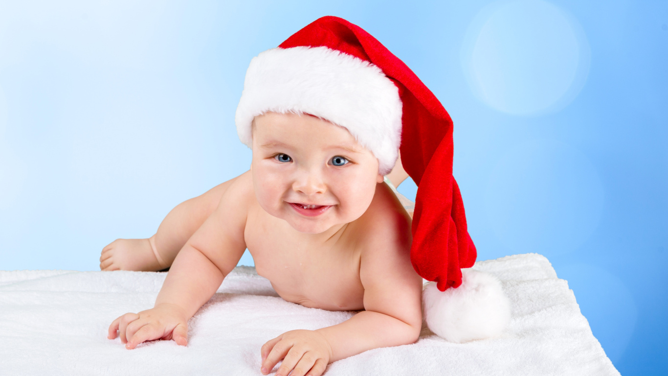 Улыбающийся грудной ребенок в новогодней шапке