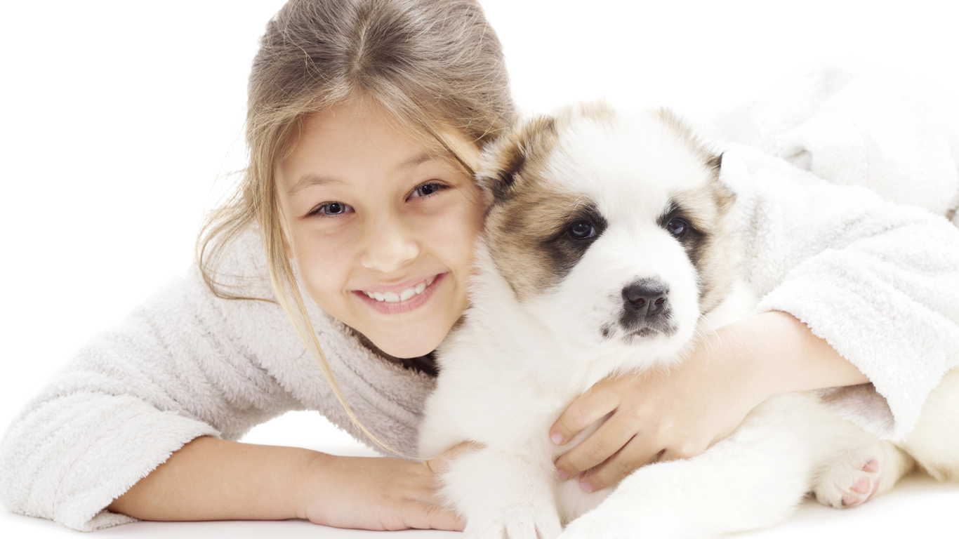 Улыбающаяся девочка с щенком алабая на белом фоне