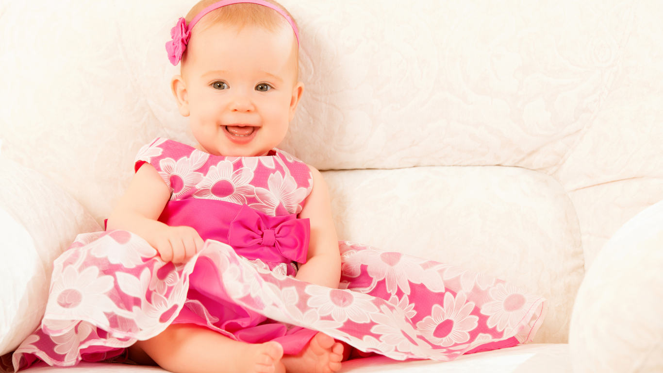 Улыбающаяся маленькая девочка в красивом розовом платье