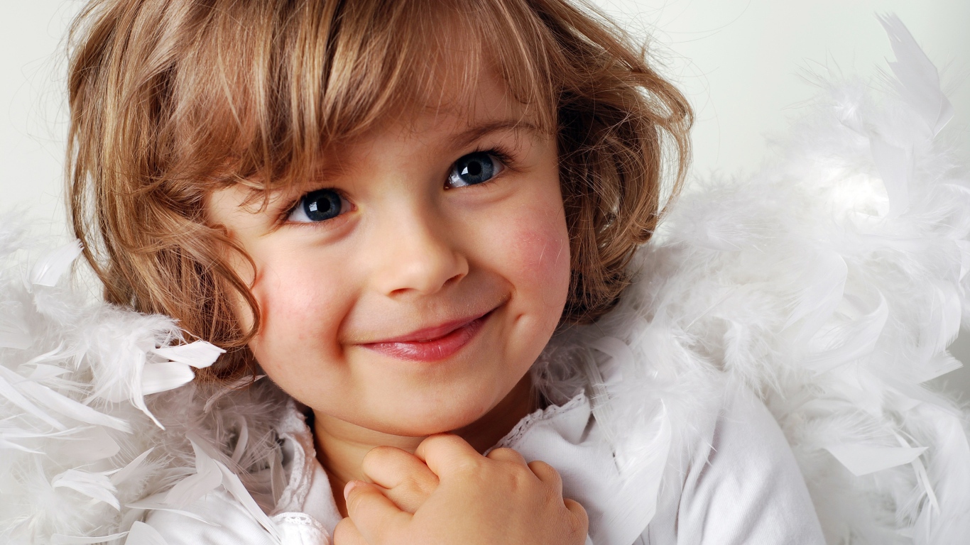 Маленькая голубоглазая девочка в костюме ангела 