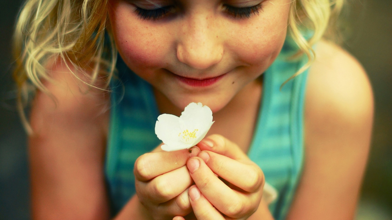 Маленькая девочка  держит белый цветок 