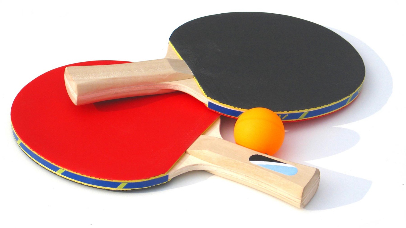 Красная и желтая ракетки и мяч на белом фоне  