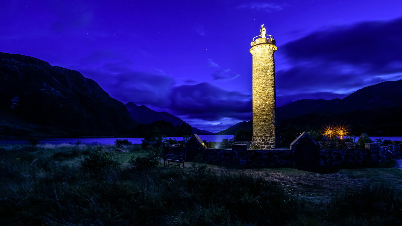 Ночной маяк у побережья на фоне гор, деревня Гленфиннан. Шотландия