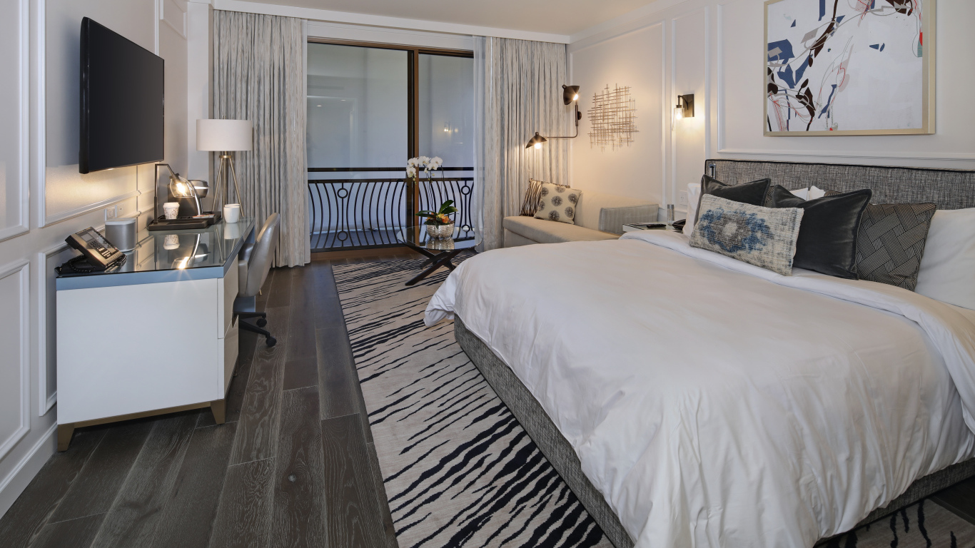 Спальня с большой кроватью и телевизором на стене