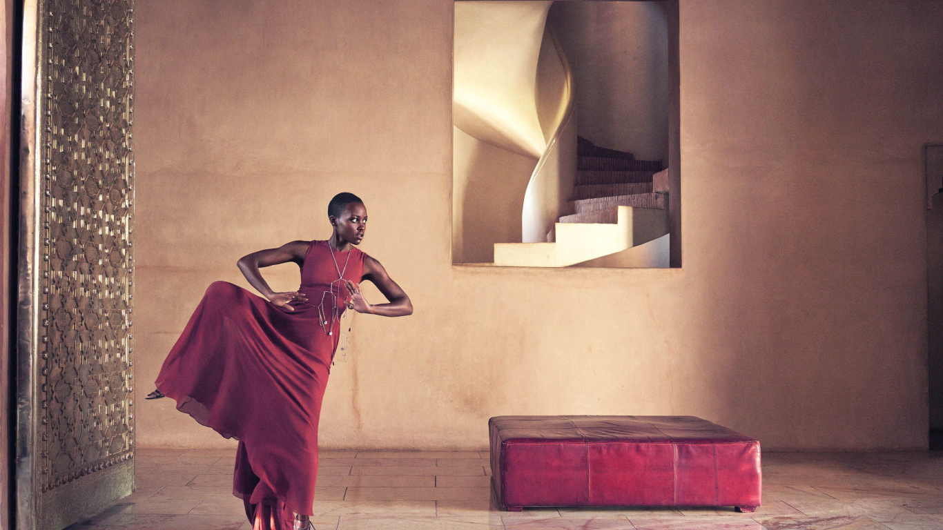 Молодая актриса Люпита Нионго танцует в красном платье