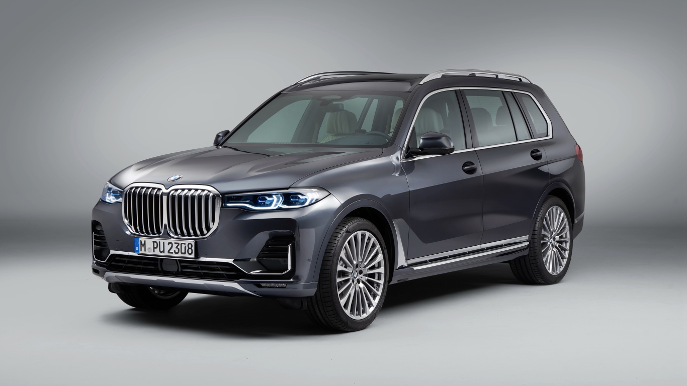 Серебристый внедорожник BMW X7, 2018 года на сером фоне