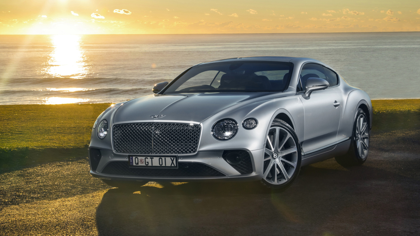 Серебристый Bentley Continental GT 2018 года на фоне моря