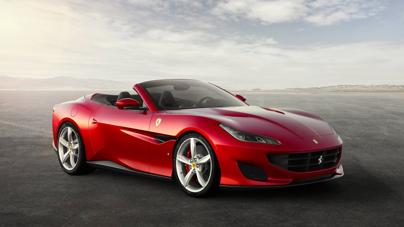 Красный автомобиль кабриолет Ferrari Portofino на фоне неба