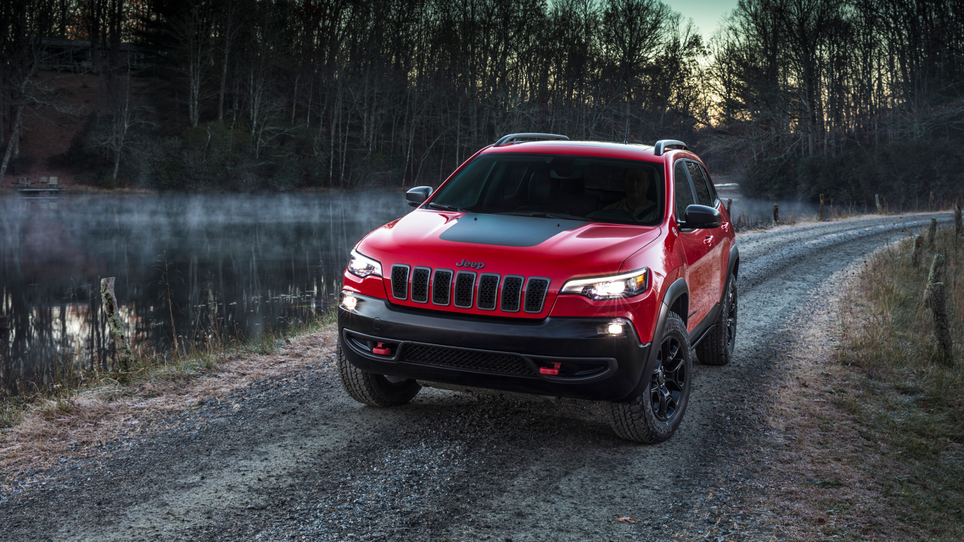 Красный автомобиль Jeep Cherokee Trailhawk, 2019 на дороге у реки