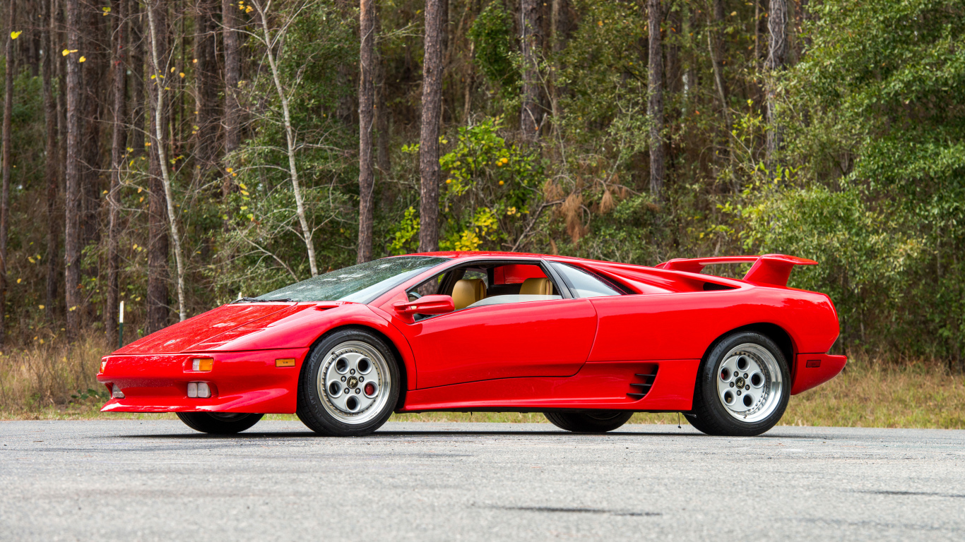 Красный спортивный автомобиль Lamborghini Diablo на фоне леса
