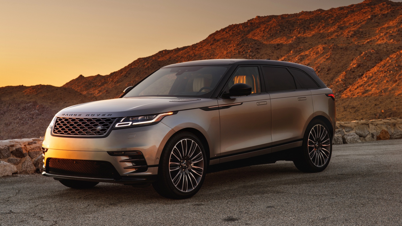 Серебристый внедорожник Land Rover 2018 года на фоне скалы 