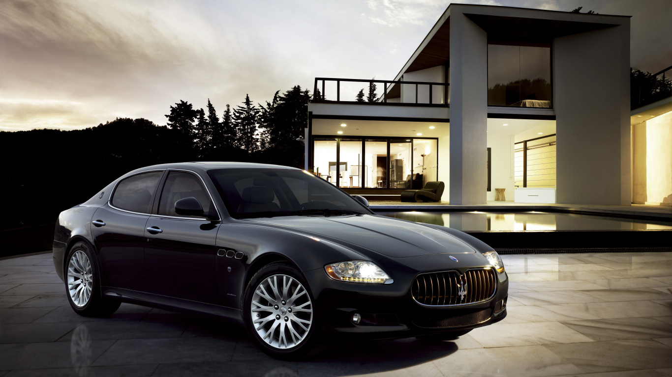 Черный автомобиль  Maserati Quattroporte у большого дома