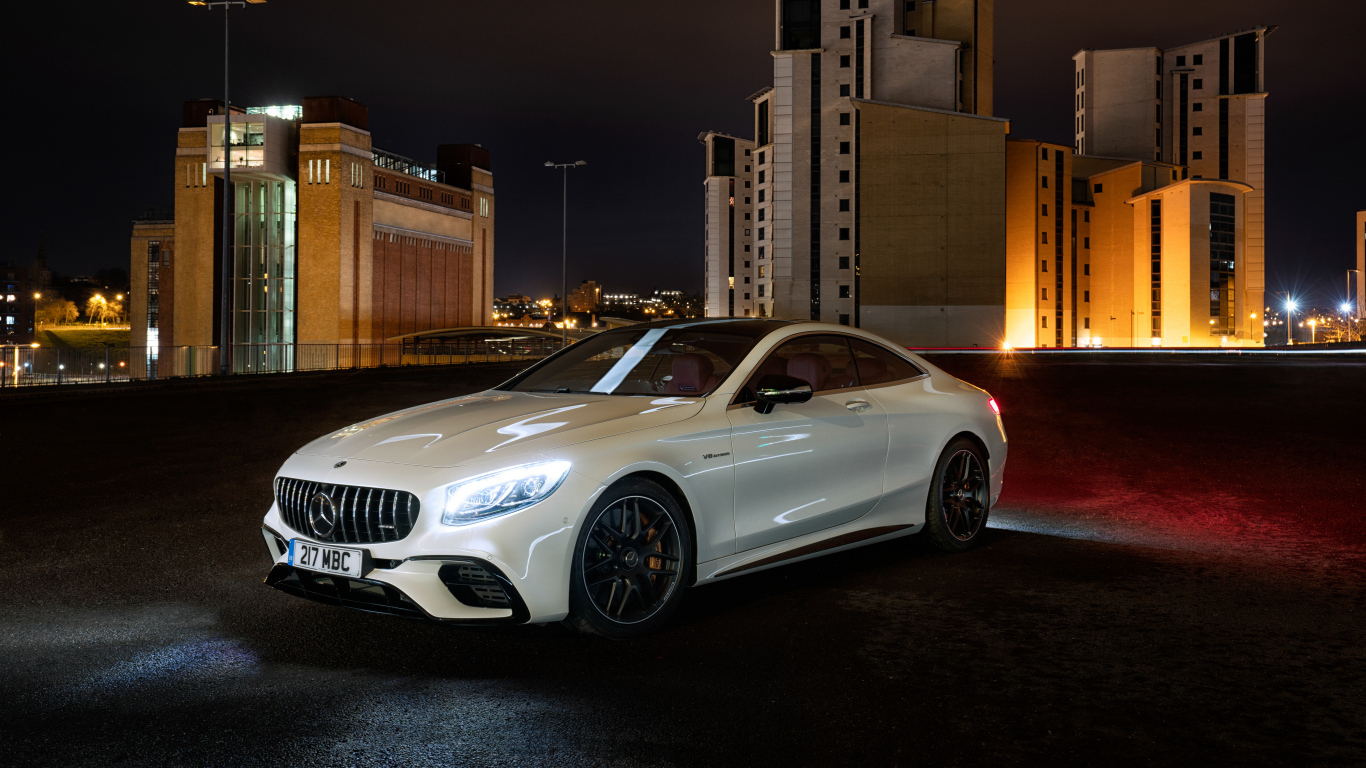 Белый автомобиль Mercedes AMG S 63 4MATIC Coupe, 2018 года на фоне города