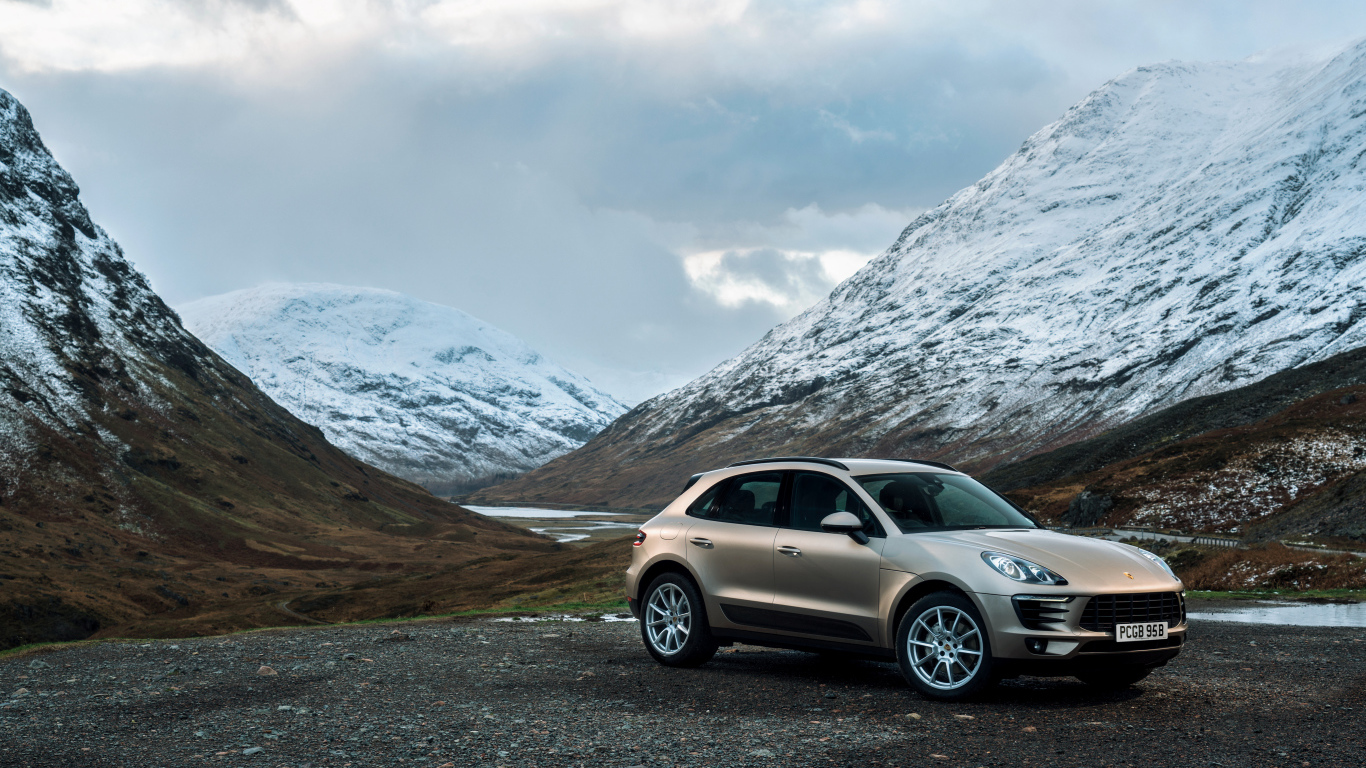 Внедорожник Porsche Macan на фоне заснеженных гор 