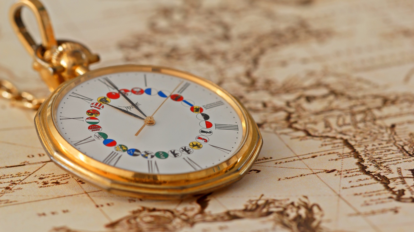 Карманные часы в золотой оправе лежат на карте