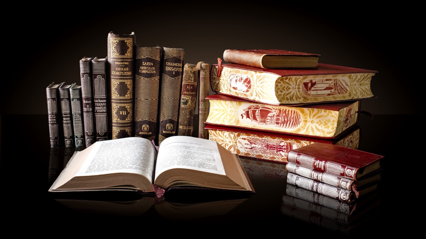 Красивые книги отражаются в зеркальной поверхности стола